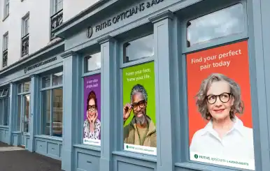 Bright storefront with eye care posters promoting optician services in the UK.