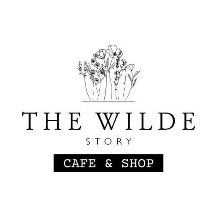Logo of The Wilde Story Cafe & Shop featuring floral artwork.